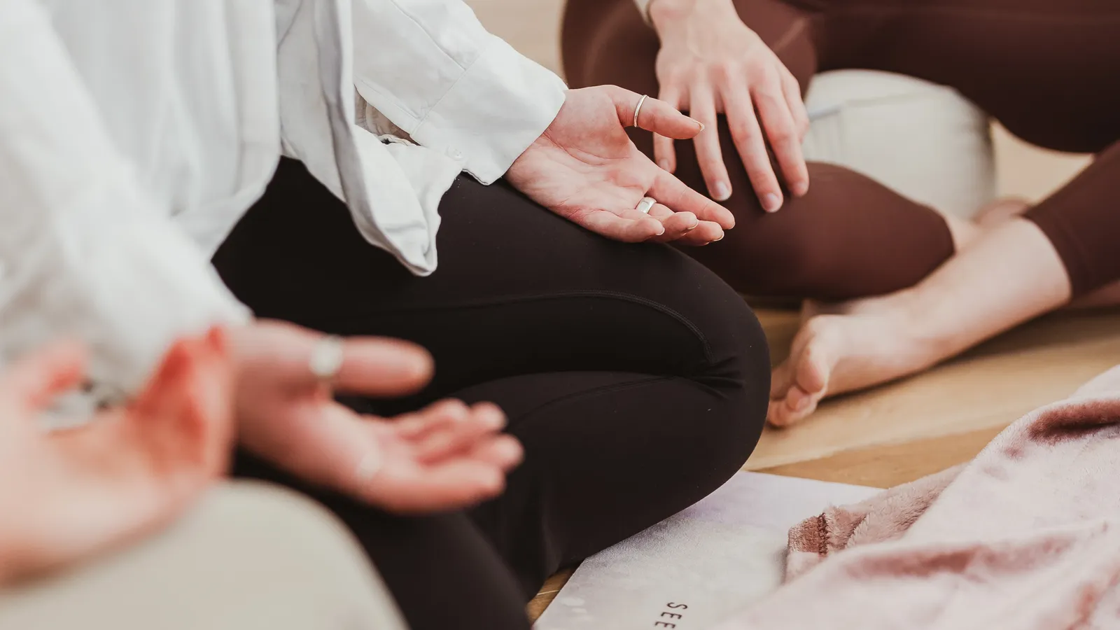 Participants sitting cross-legged with hands resting open on their knees during a breathwork session at Davaar House