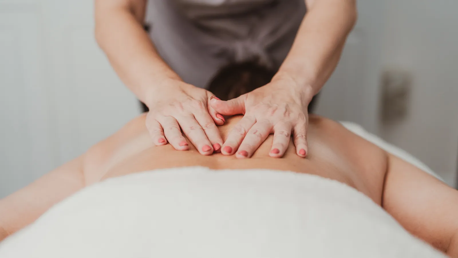 Therapist's hands working across a client's back during a massage at Davaar House