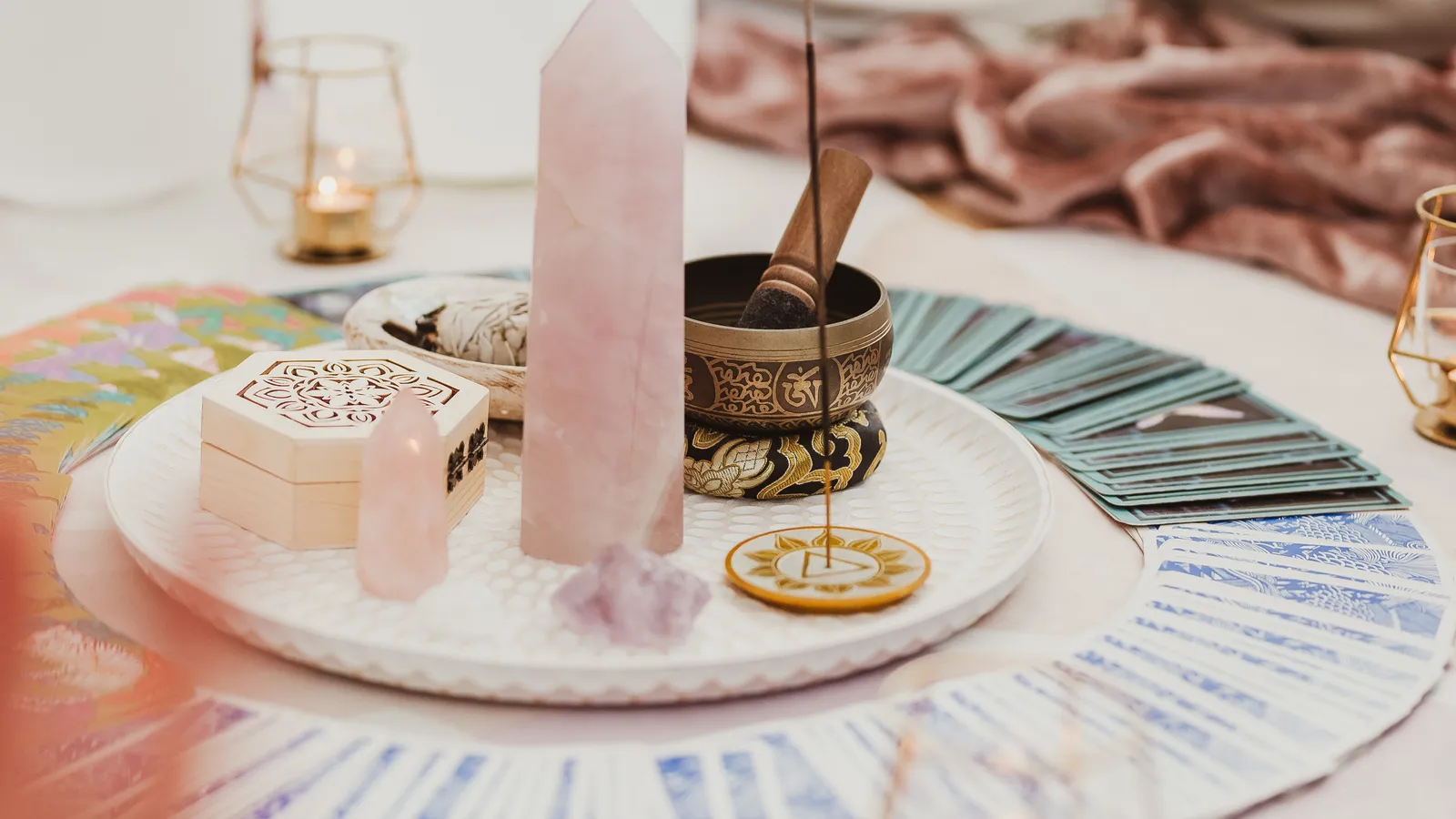 Centrepiece of crystals, oracle cards, a singing bowl and candles laid out for a circle at Davaar House, with participants seated around it