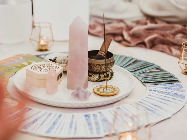 Centrepiece of crystals, oracle cards, a singing bowl and candles laid out for a circle at Davaar House, with participants seated around it